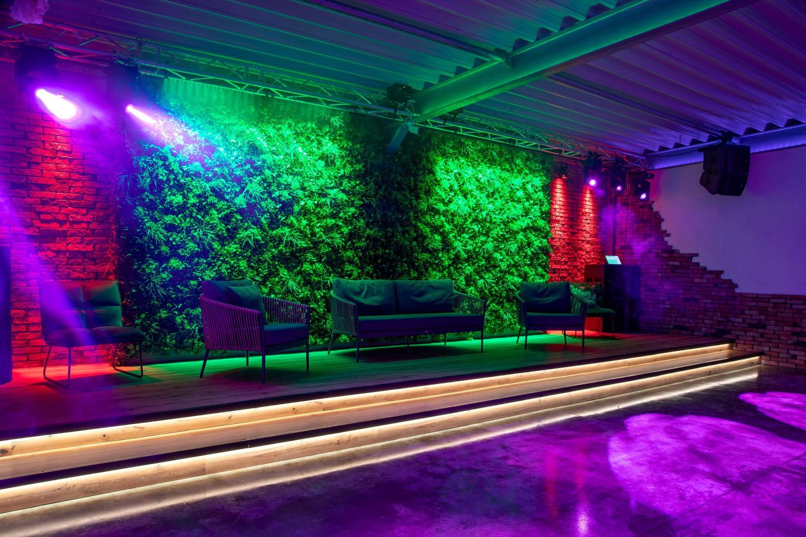 Saal in Magenta mit Mooswand und Sitzbänken